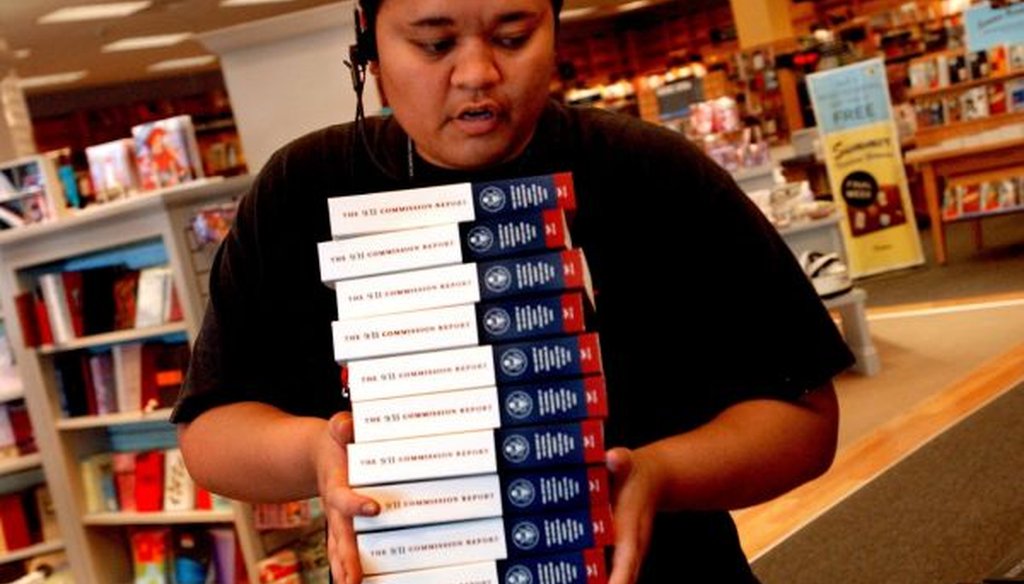 Tabitha Kepilino, a training supervisor at Borders in Clearwater, Fla., stocks tables with the final report of the 9/11 Commission in 2004. (Cherie Diez/Tampa Bay Times)