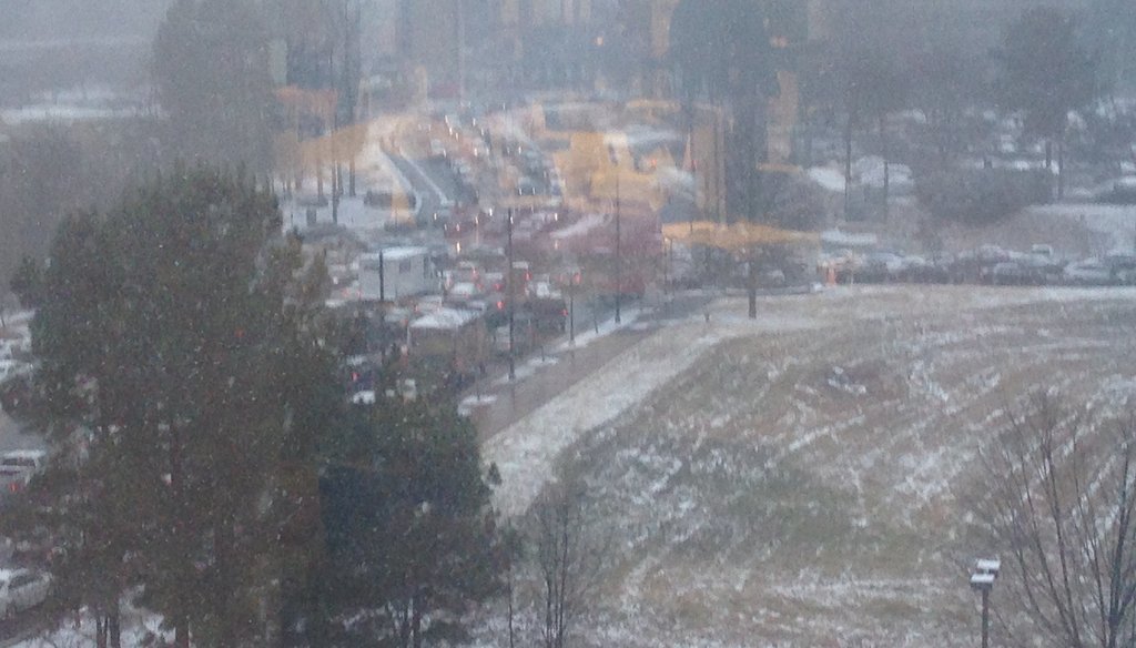 Traffic was snarled near Perimeter Mall as snow fell upon the Atlanta region Tuesday afternoon. A state official initially said the roads were not "terrible" by 3 p.m. Photo credit: Eric Stirgus/AJC.