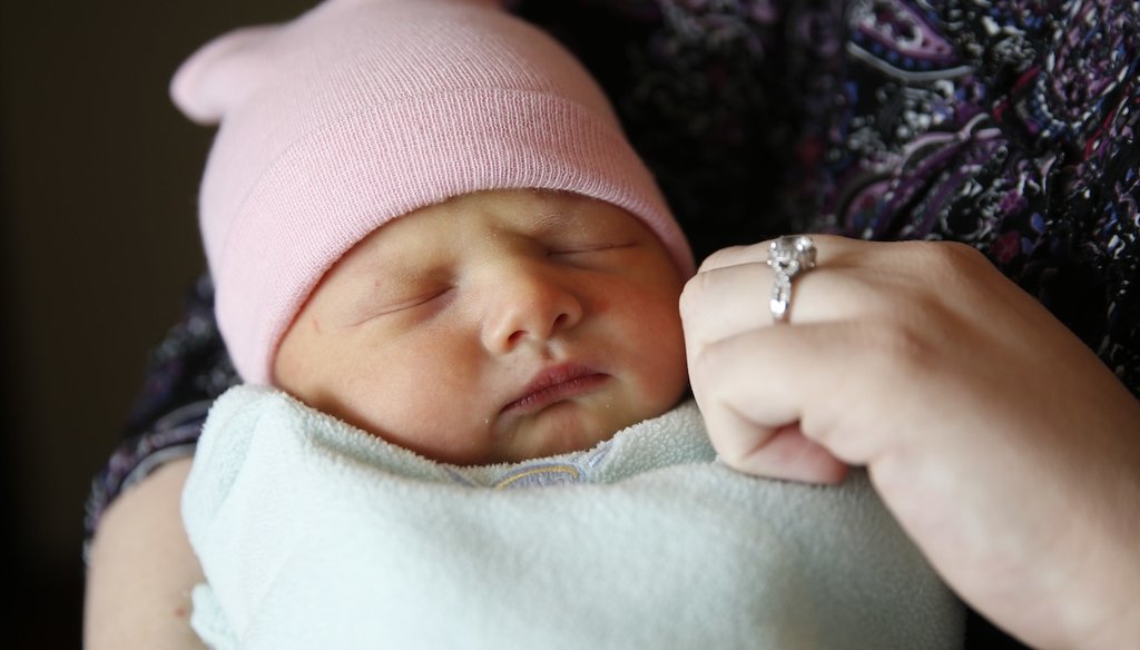 A mother holds her newborn child after her blood was collected at Community Hospital North in Indianapolis on May 12, 2016. (AP)