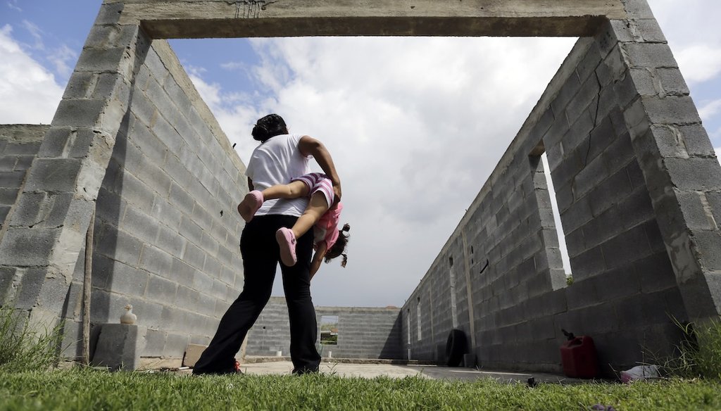 A woman who is in the country illegally plays with her 2-year-old daughter, who was born in the United States but was denied a birth certificate and was fighting that decision in the courts, in Sullivan City, Texas in 2015. (AP)