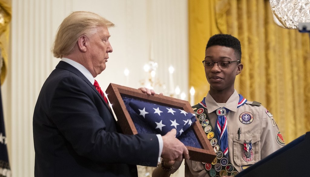 President Donald Trump presents an American flag flown on Marine One to Eagle Scout Alphonso Hill Jr. during an Black History Month reception in the East Room of the White House, Feb. 27, 2020, in Washington. (AP)
