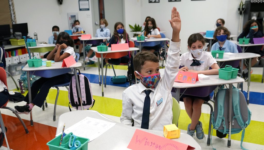 Student Winston Wallace, 9, raises his hand in class at iPrep Academy on the first day of school, Aug. 23, 2021, in Miami. Public schools in Miami-Dade County have a strict mask mandate to guard against coronavirus infections. (AP)