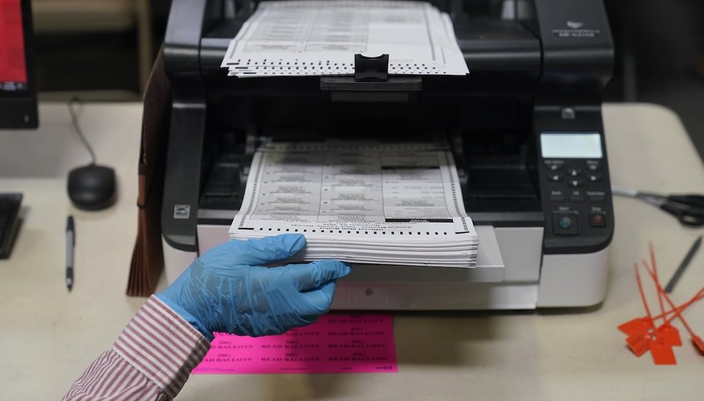 A county worker loads mail-in ballots into a scanner that records the votes at a tabulating area at the Clark County Election Department in Las Vegas on Oct. 29, 2020. (AP)