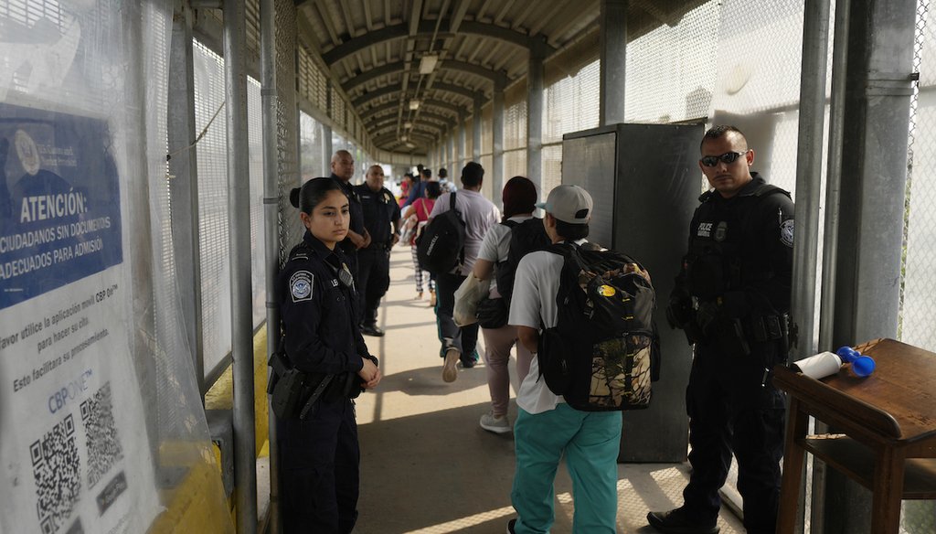 La Policía de la Oficina de Aduanas y Protección Fronteriza monitorea a migrantes que caminan a través de un puente de Matamoros, México, el 12 de mayo de 2023. (AP)