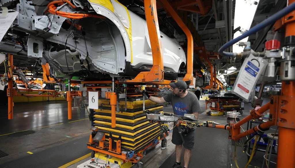 Assembly line worker Ryan Pontillo attaches an LG battery to a 2023 Chevrolet Bolt EV at the General Motors Orion Assembly, June 15, 2023, in Lake Orion, Mich. (AP)