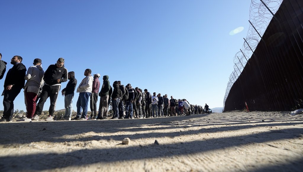 Men line up to receive food from volunteers with Border Kindness after crossing the border with Mexico, Oct. 24, 2023, near Jacumba, Calif. (AP)