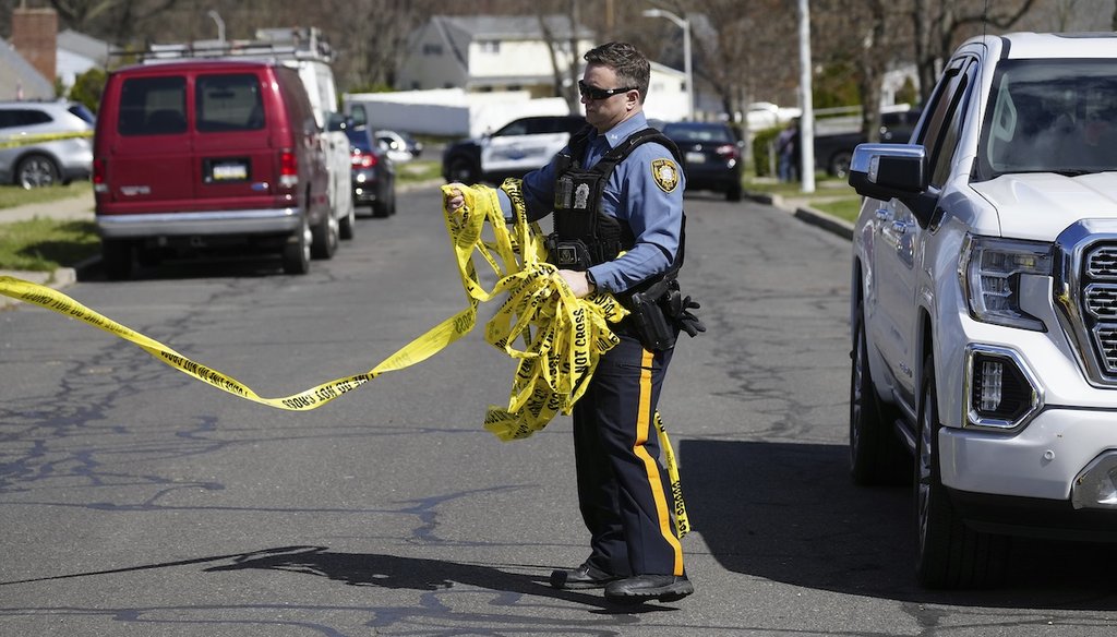 A police officer removes crime scene tape after a shooting in Levittown, Pa., on March 16, 2024.  (AP)