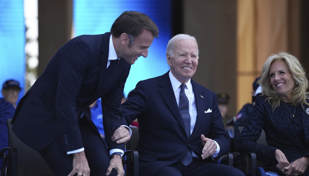 President Joe Biden and French President Emmanuel Macron react with First Lady Jill Biden during a commemorative ceremony to mark D-Day 80th anniversary, Thursday, June 6, 2024 at the US cemetery in Colleville-sur-Mer, Normandy.