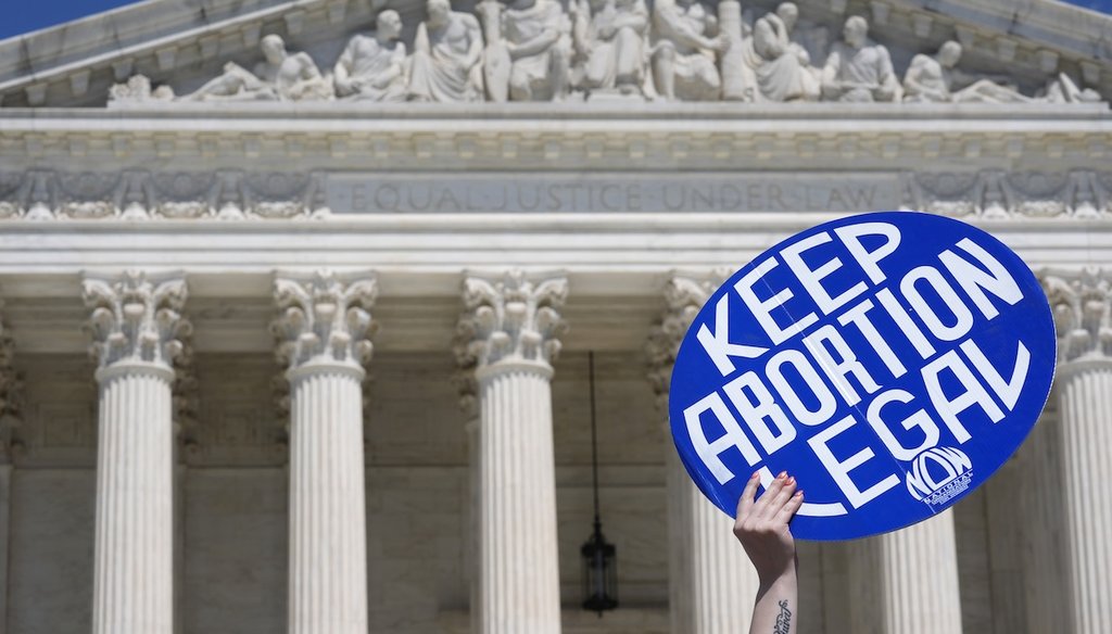 A person holds up a sign as abortion-rights activists and Women's March leaders protest June 24, 2024, as part of a national day of strike actions outside the Supreme Court in Washington. (AP)