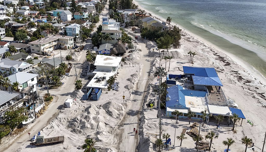 In this image taken with a drone, Sand washed ashore by the surge from Hurricane Helene fills the streets, Oct. 2, 2024, in Treasure Island, Fla. (AP