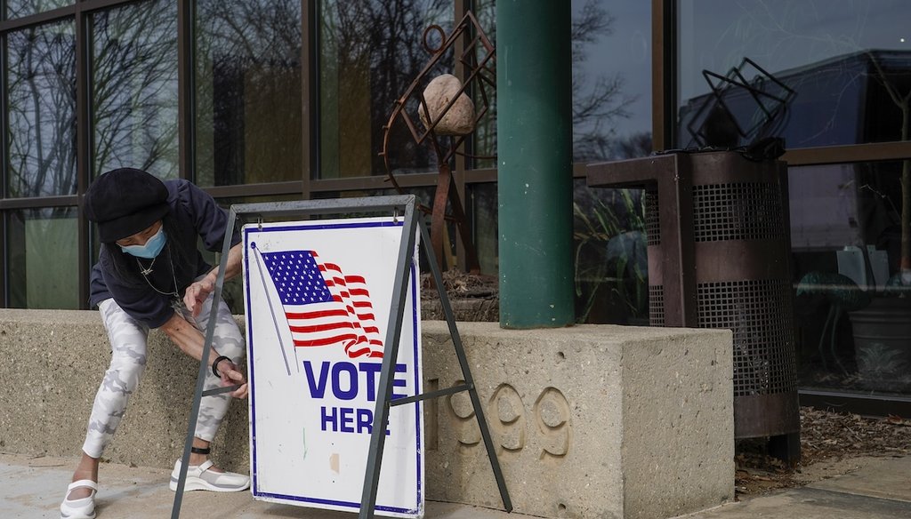 Poll worker Pranee Sheskey puts up a sign outside the Warner Park Community Recreation Center for the first day of early voting in in Madison, Wis., on March 21, 2023. (AP)