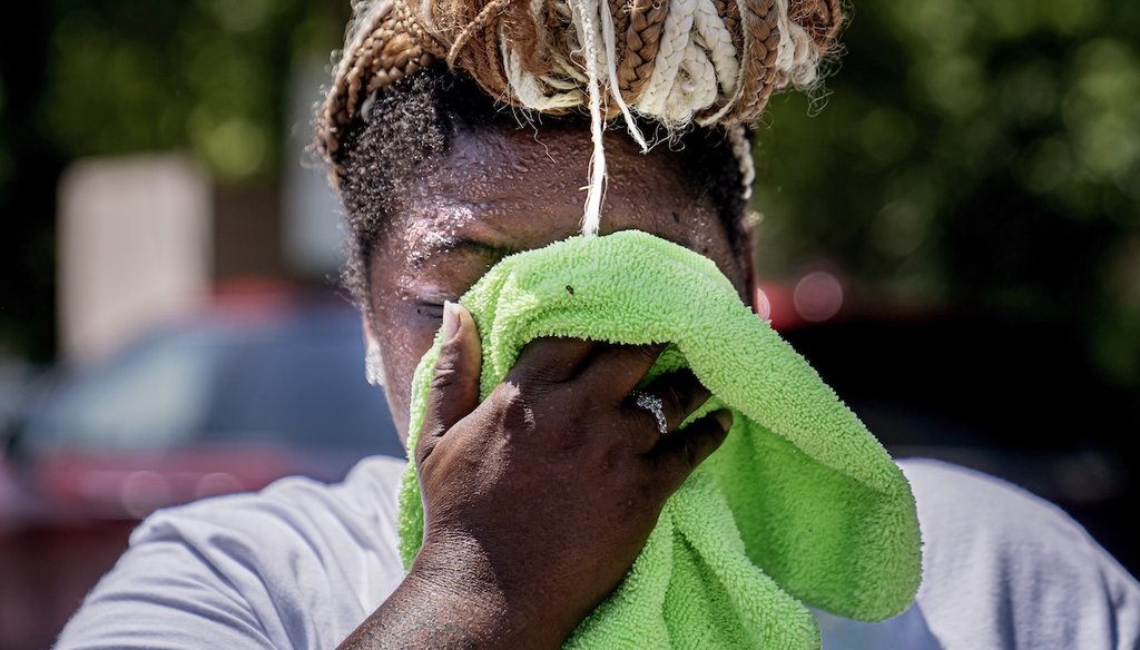Nicole Brown wipes sweat from her face while setting up her beverage stand near the National Mall on July 22, 2022, in Washington. (AP)
