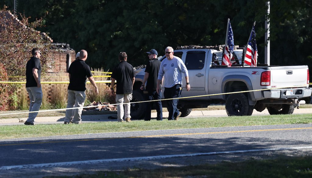 Law enforcement officials stand outside the vehicle used to ram the exterior of the Church of Jesus Christ of Latter-day Saints, Sept. 29, 2025 in Grand Blanc Township, Mich. (AP)
