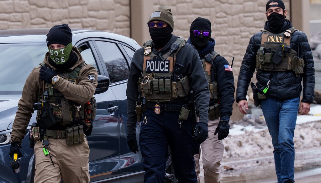 Agentes del Servicio de Control de Inmigración y Aduanas, incluido uno que llevaba una mascarilla con la inscripción "NO SOY DE ICE", caminan cerca de sus vehículos el 15 de enero de 2026 en Richfield, Minnesota. (AP)