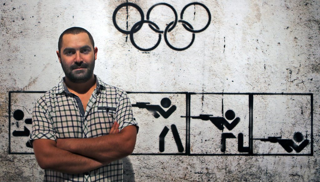 Syrian artist Tammam Azzam poses in front of his digital print, "Syrian Olympic," during the Young Collectors Auction at Ayyam gallery in Dubai, United Arab Emirates, Monday, Sept. 16, 2013. Another of his works is a frequently mischaracterized. (AP)