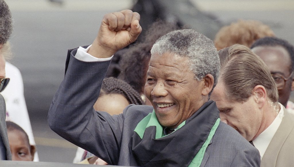 Nelson Mandela arrives at Washington's National Airport, June 24, 1990, and salutes the crowd who are waiting for him. Mandela will visit President George H.W. Bush while in Washington. (AP)