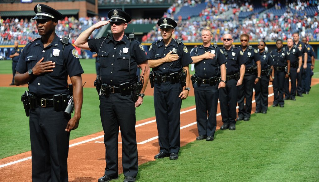 Atlanta police officers pay their respects during a memorial of the Sept. 11, 2001 terrorist attacks. Mayor Kasim Reed and police say an increase in the number of officers hired has contributed to a drop in felony crimes.