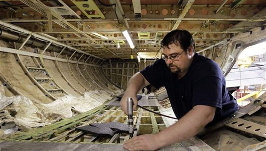 Chris Book, who was accepted into a sheet-metal apprentice program, performs maintenance work on the floor in the cargo hold of a Boeing 737. (AP)