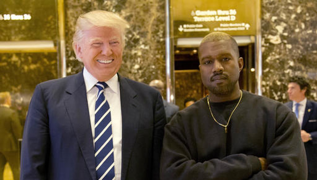 Donald Trump, then the president-elect, poses with Kanye West in the lobby of Trump Tower in New York on Dec. 13, 2016. (AP/Seth Wenig)
