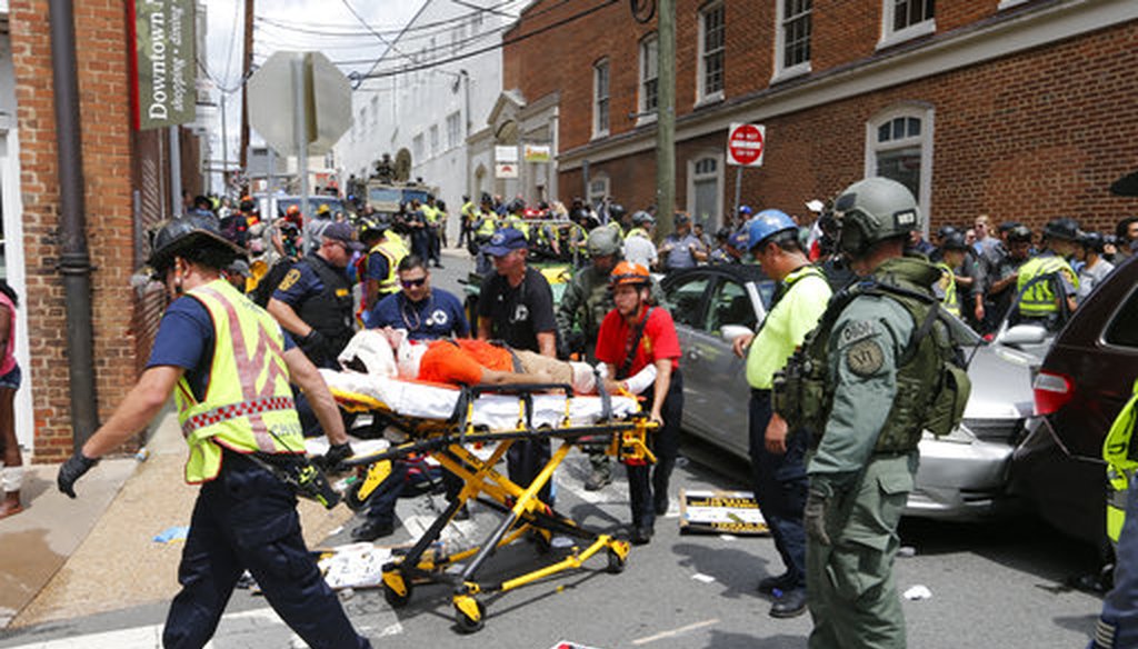 Rescue personnel help injured people after a car ran into a large group of counter-protesters at a white nationalist rally in Charlottesville, Va., Aug. 12, 2017. (AP/Steve Helber)