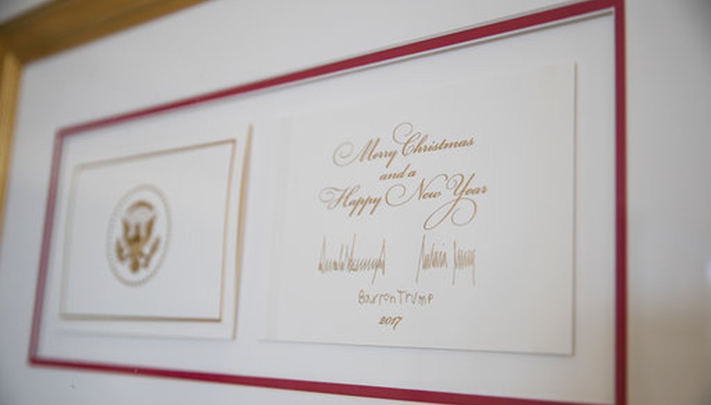 The official White House Christmas card signed by President Donald Trump, first lady Melania Trump, and their son Barron Trump at the White House, Nov. 27, 2017. (AP Photo/Carolyn Kaster)