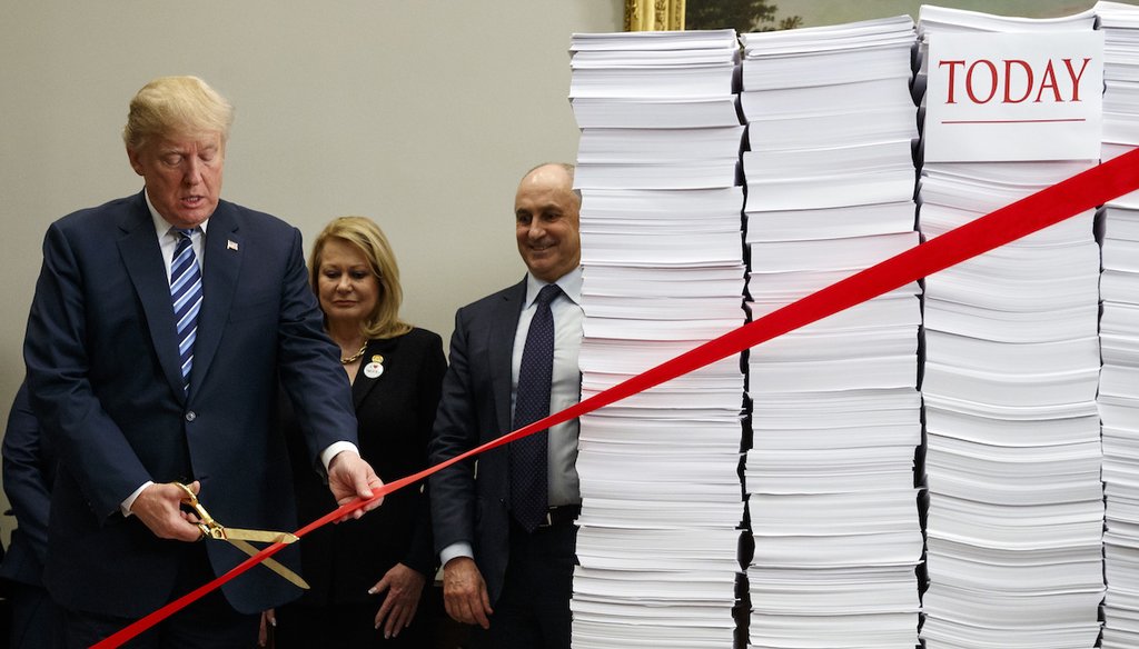 President Donald Trump cuts a ribbon celebrating record deregulations on Dec. 14, 2017, in Washington.