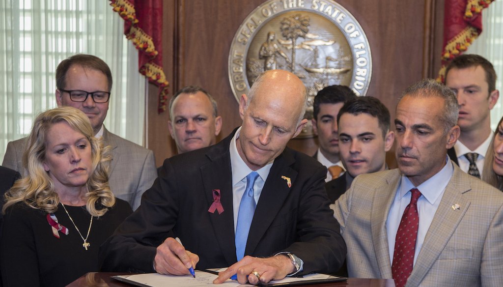In this March 9, 2018 file photo, Florida Gov. Rick Scott signs the Marjory Stoneman Douglas Public Safety Act in the governor's office at the Florida State Capitol in Tallahassee, Fla. (AP Photo/Mark Wallheiser, File)