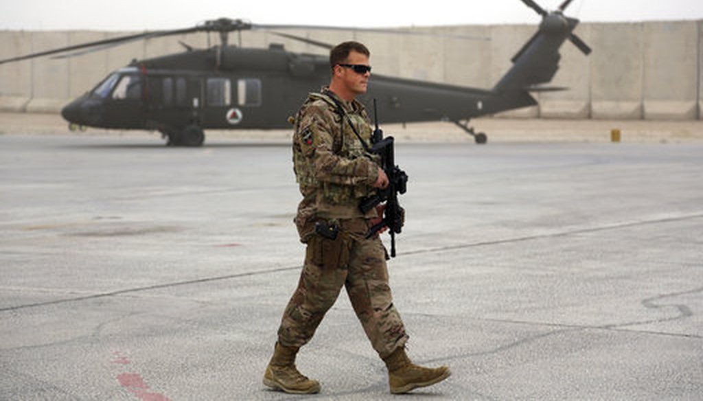 A U.S. adviser walks near a UH-60 Black Hawk helicopter at Kandahar Air Field, Afghanistan, on March 18, 2018. (AP/Rahmat Gul)