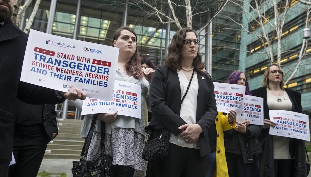 Plaintiff U.S. Army Ssg Katie Schmid, center, listens to a speaker during a press conference following oral arguments in a case to block a transgender military ban at the U.S. Western District Federal Courthouse on March 27, 2018 in Seattle. (AP)