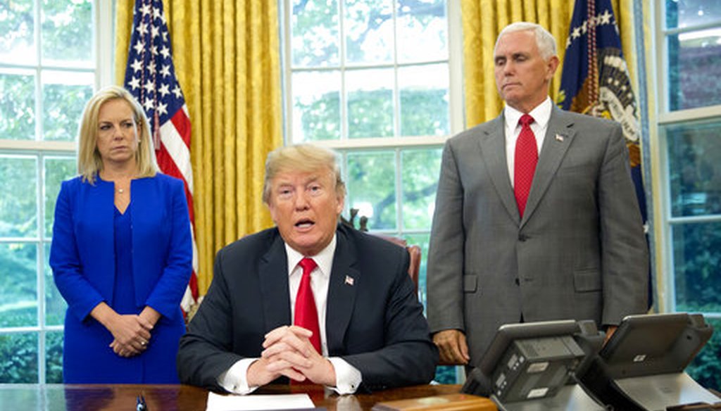 President Donald Trump with Homeland Security Secretary Kirstjen Nielsen and Vice President Mike Pence, signs an executive order to end family separations. (AP Photo/Pablo Martinez Monsivais)