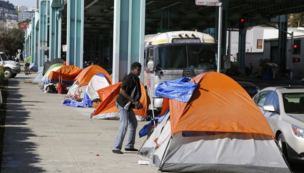 A man stands outside his tent in San Francisco in 2016 in a neighborhood with many homeless people. (AP)