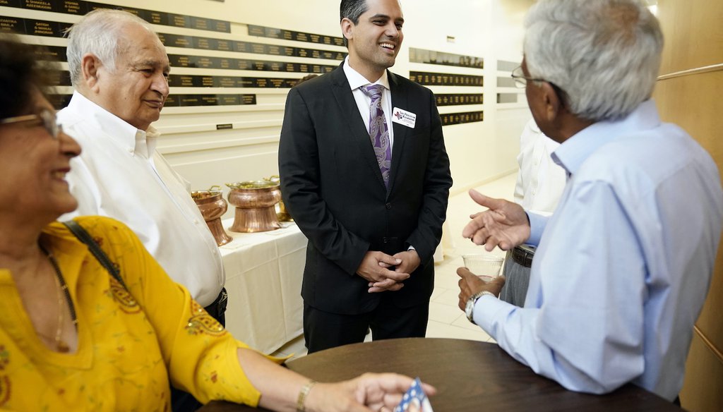 Democrat for Congress candidate Sri Kulkarni, center, listens to supporters attending a fundraiser for him. (AP)