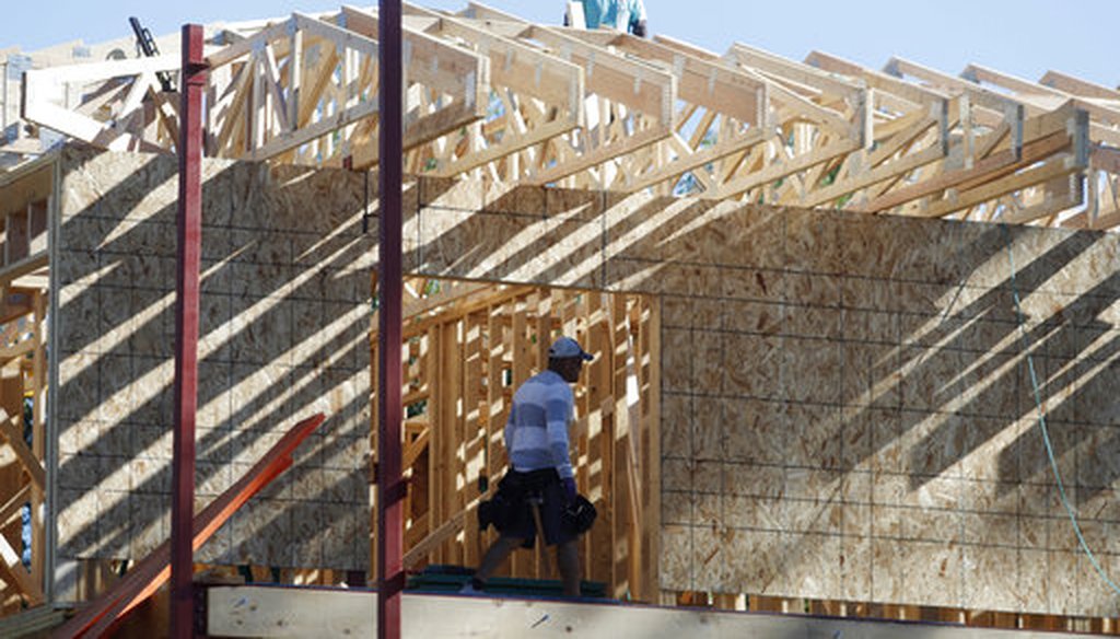 Workers toil on a new home under construction. (AP/David Zalubowski)