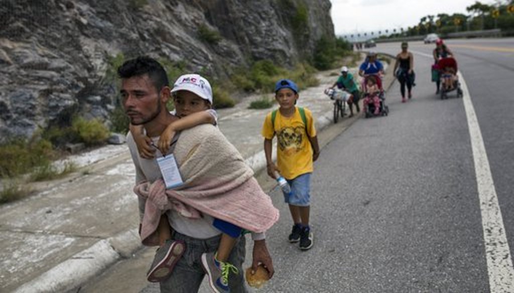 Honduran migrant Jose Macy carries his four-year-old nephew Yair Perez as the thousands-strong caravan of Central Americans migrants hoping to reach the U.S. border moves onward from Juchitan, Oaxaca state, Mexico, on Thursday, Nov. 1, 2018. (AP)