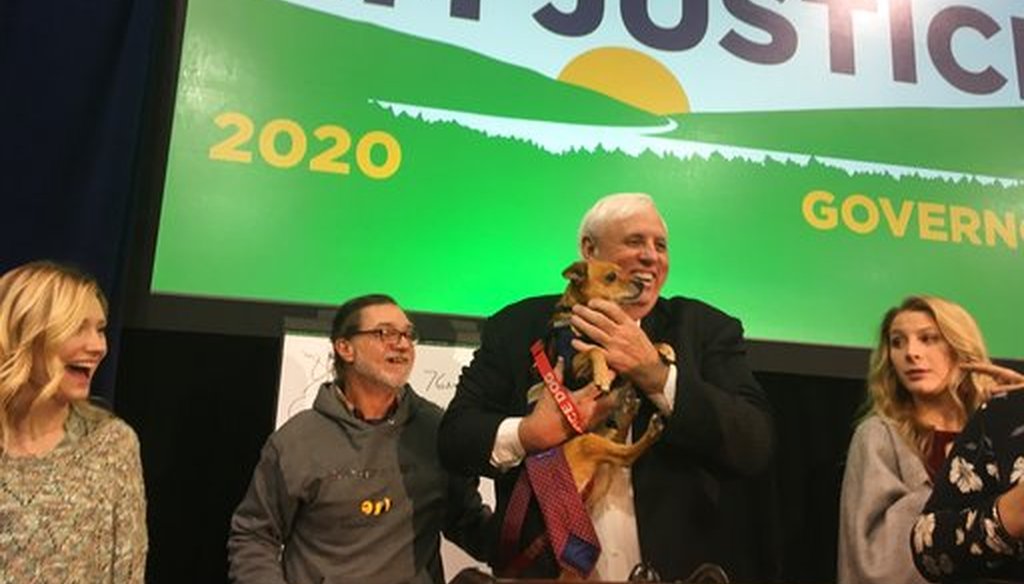 West Virginia Gov. Jim Justice holds a service dog onstage after announcing on Jan. 7, 2019, that he will seek re-election in 2020. (AP)