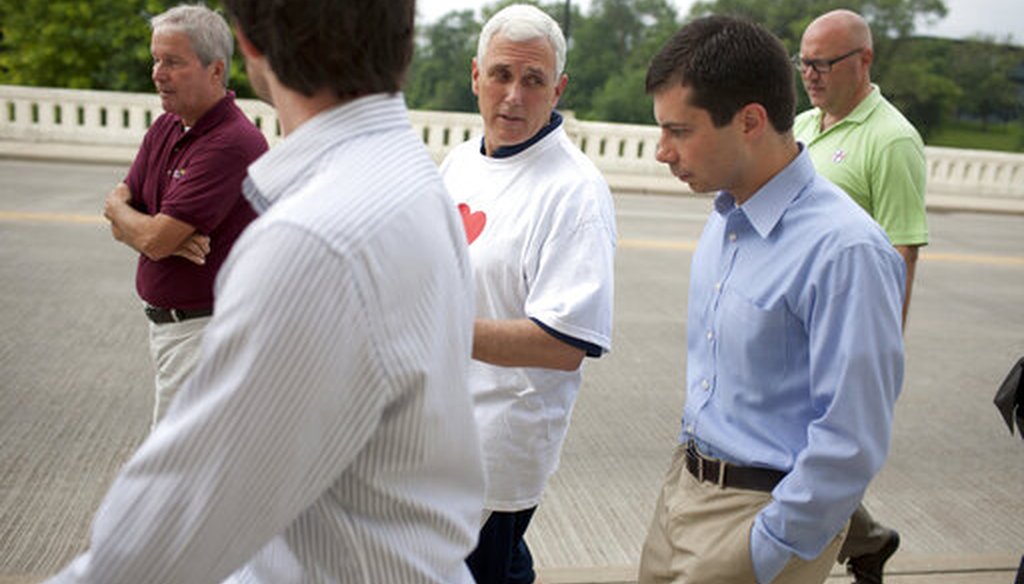 Then-Indiana Gov. Mike Pence, center, talks with South Bend, Ind., Mayor Pete Buttigieg, right, as they cross the Jefferson Boulevard bridge during a fitness walk along the St. Joseph River in South Bend on July 3, 2013. (AP)