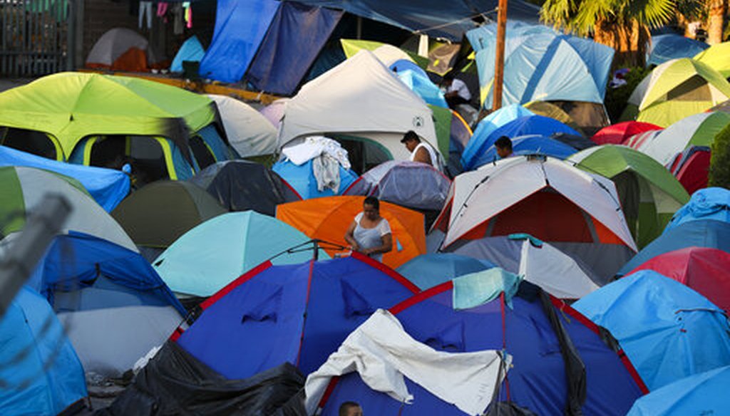 In this Oct. 11, 2019 photo, migrants wake up at a camp near a legal port of entry bridge in Matamoros, Mexico. Due to Trump administration policies, they remain here for weeks and sometimes months as they await their U.S. court dates. (AP/Fernando Llano)