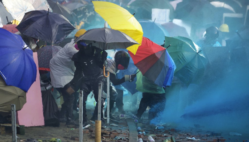 Hong Kong police spray blue-dyed liquid at protesters. (AP)