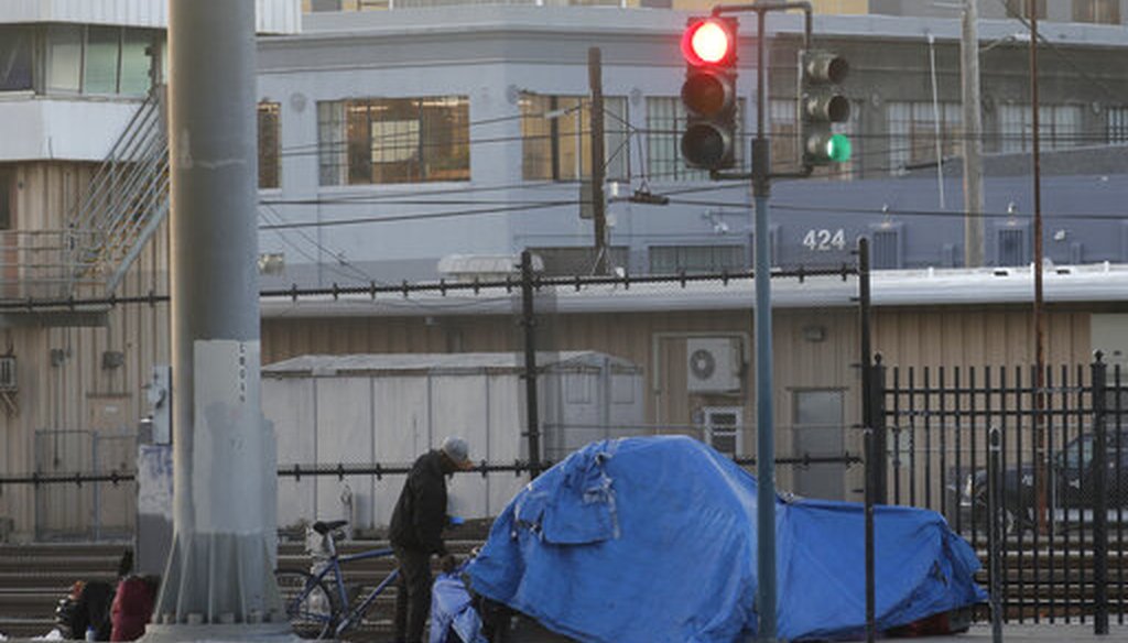 A man stands by a tent in San Francisco on Jan. 14, 2020. (AP/Chiu)