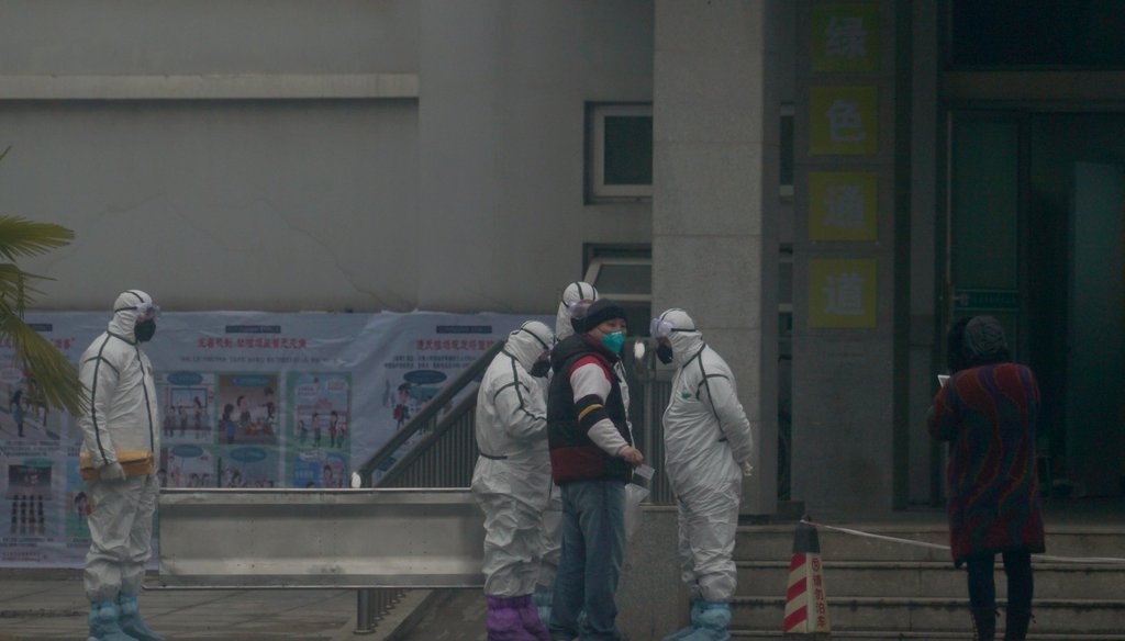 Staff in biohazard suits hold a metal stretcher by the in-patient department of Wuhan Medical Treatment Center, where some infected with a novel coronavirus are being treated, in Wuhan, China on Jan. 21, 2020. (AP)