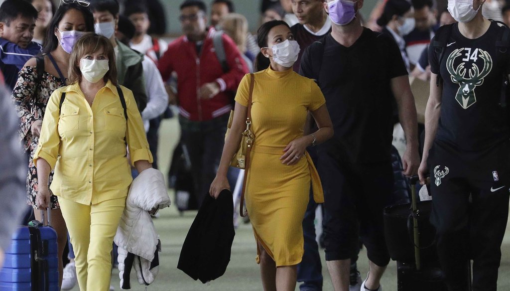Passengers wear masks as they arrive at Manila's international airport, Philippines, on Jan. 23, 2020. (AP)
