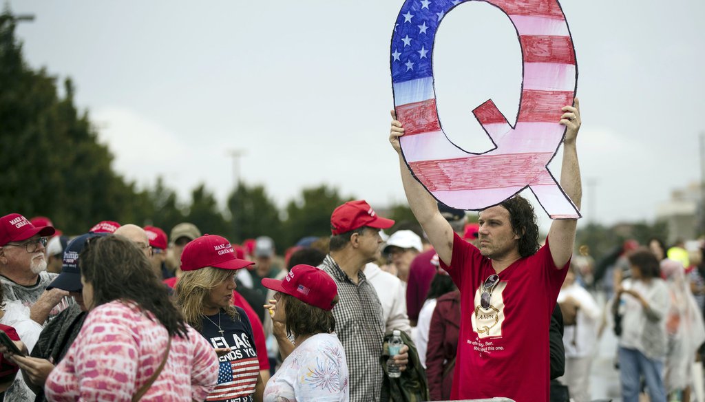 In this Aug. 2, 2018, file photo, David Reinert holding a Q sign waits in line with others to enter a campaign rally with President Donald Trump in Wilkes-Barre, Pa. (AP)