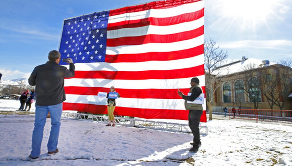 Supporters of Democratic presidential candidate Bernie Sanders take pictures in front of a large American flag before a rally in Salt Lake City on March 2, 2020, a day before the Super Tuesday primaries. (AP)