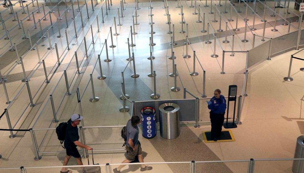 A TSA agent speaks to travelers passing through an empty security queue at Love Field airport in Dallas on March 12, 2020, amid concerns of the coronavirus pandemic. (AP)