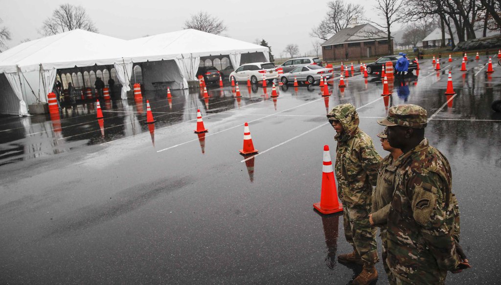 National Guard personnel stand beside a line of motorists waiting for COVID-19 coronavirus infection testing at Glen Island Park in New Rochelle, N.Y., on March 13, 2020, (AP)