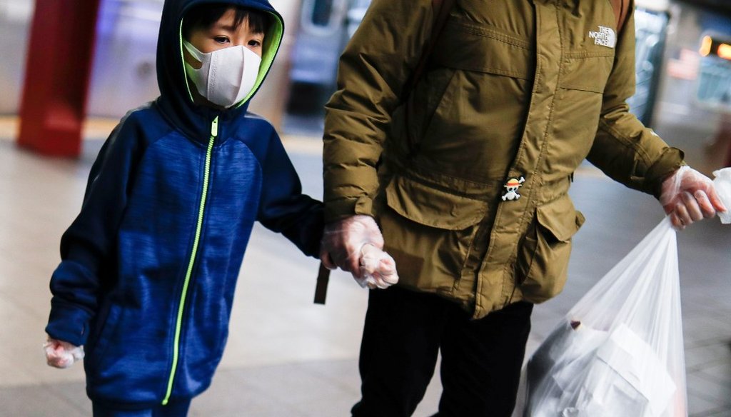 A child wears a protective mask and gloves in the subway system due to COVID-19 concerns, Thursday, March 19, 2020, in New York. (AP)