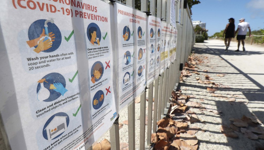 Coronavirus prevention flyers attached to a fence of the town's community center are shown on March 21, 2020, in Surfside, Fla. (AP)