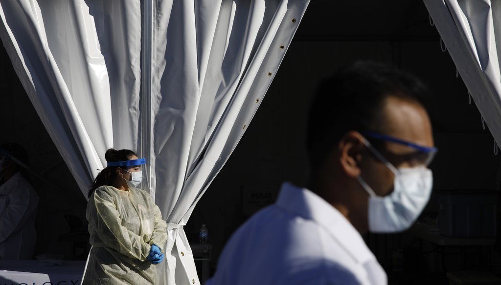 Health care workers with the UNLV School of Medicine wait in personal protective equipment for patients at a drive thru coronavirus testing site on March 24, 2020, in Las Vegas. (AP)
