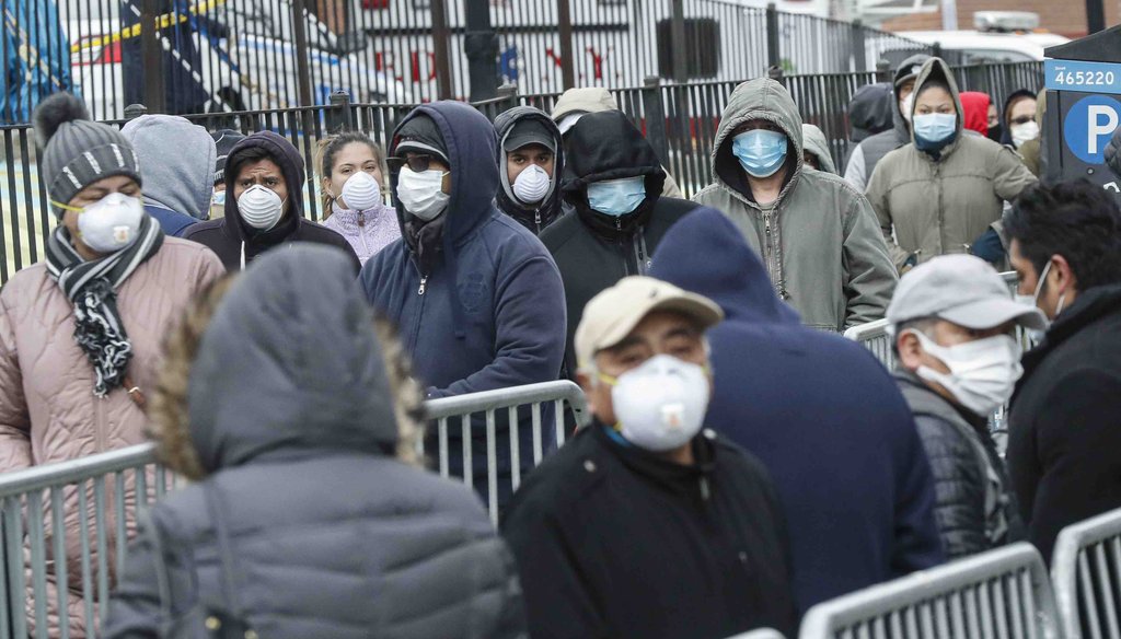 Patients wear personal protective equipment while maintaining social distancing as they wait in line for a COVID-19 test at Elmhurst Hospital Center on March 25, 2020, in New York. (AP)
