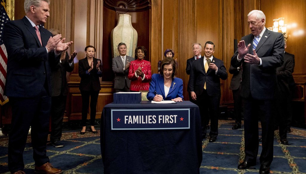 House Speaker Nancy Pelosi of California signs the Coronavirus Aid, Relief, and Economic Security (CARES) Act after it passed in the House on Capitol Hill on March 27, 2020, in Washington. (AP)